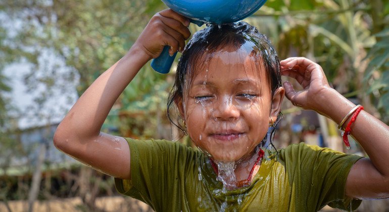 在柬埔寨,一名小女孩的家中使用新安装的自来水洗脸.